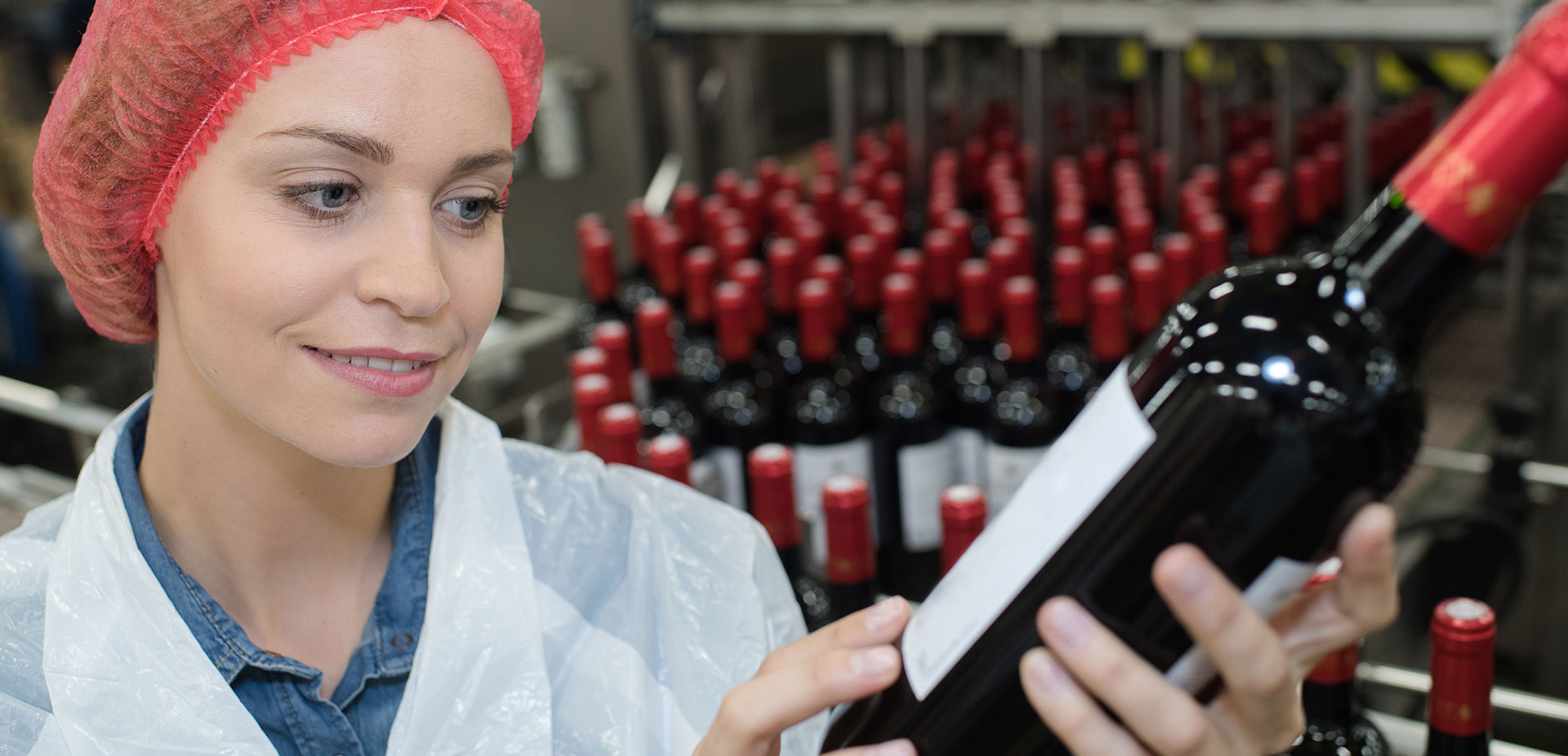 Frau begutachtet Weinflasche mit Etikett